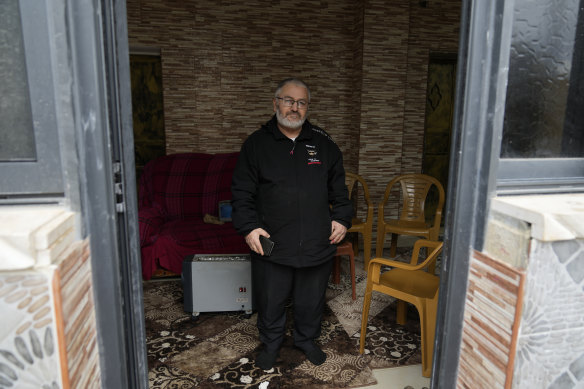 Mohammed Shula poses for a photo inside a relative’s house where he and his wife have taken refuge in the West Bank.