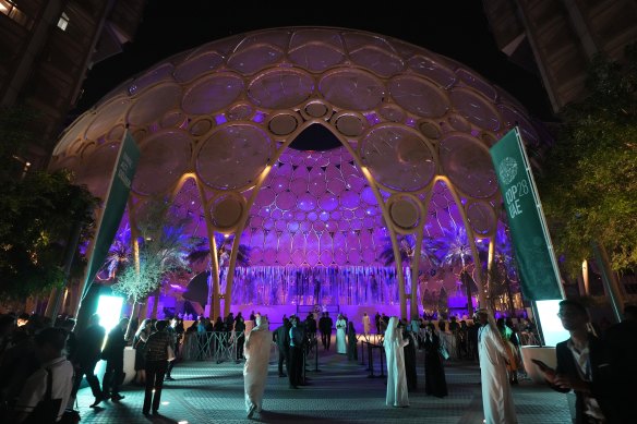 People walk near a lit up Al Wasl Dome at Expo City at the COP28 U.N. Climate Summit.
