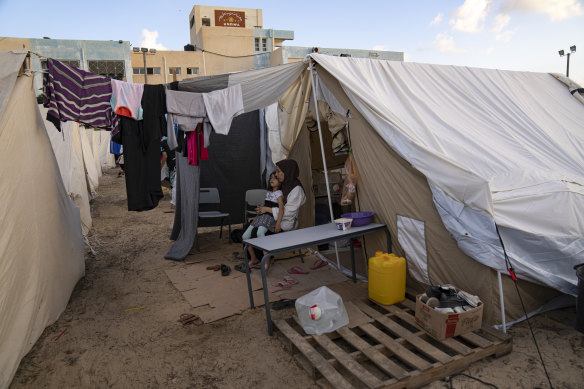 Displaced Palestinians sit in a tent camp in Khan Younis