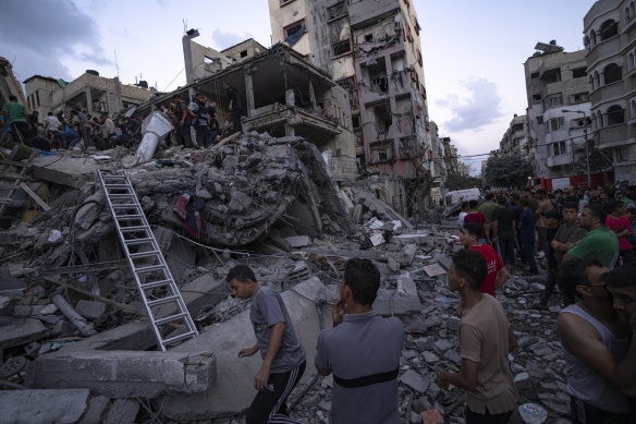 Palestinians look for the injured in the rubble of a destroyed building.