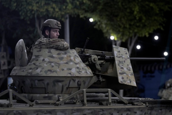 A Lebanese soldier sits behind his weapon on the top of an armoured personnel carrier at the site of an Israeli airstrike in Beirut’s southern suburb on Monday.