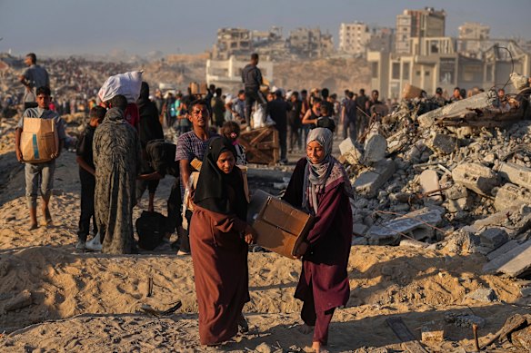 Palestinians carry pockets and boxes of food and humanitarian aid unloaded by a world program convoy that was heading to Gaza City.