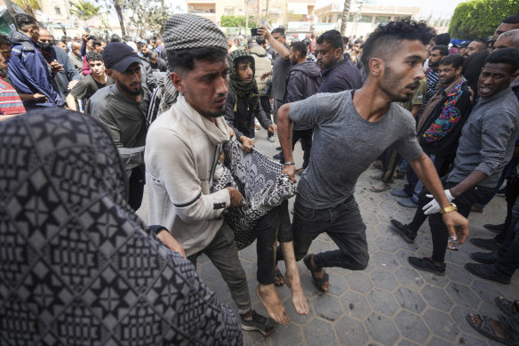 A wounded person is carried to hospital following an Israeli airstrike near the Al Aqsa hospital in Deir al-Balah in Gaza on Sunday.