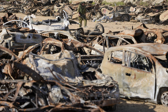 An Israeli soldier inspects charred vehicles burned in the bloody Oct. 7 cross-border attack by Hamas militants.