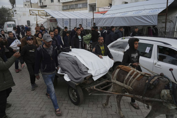 Mourners carry the bodies of Palestinians including children who were killed by an Israeli airstrike, on Friday.