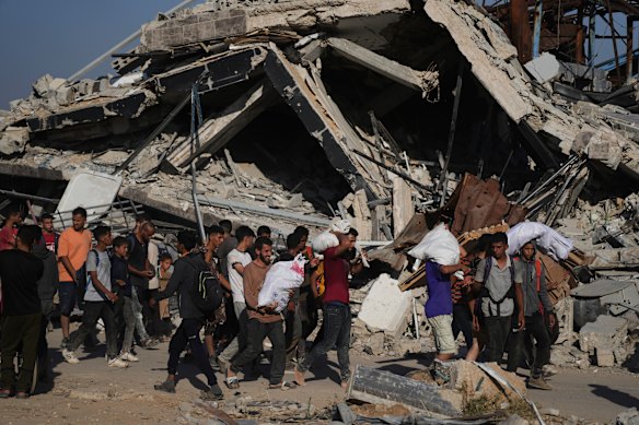 Palestinians carry humanitarian aid packages distributed by the Gaza Humanitarian Foundation on Thursday.