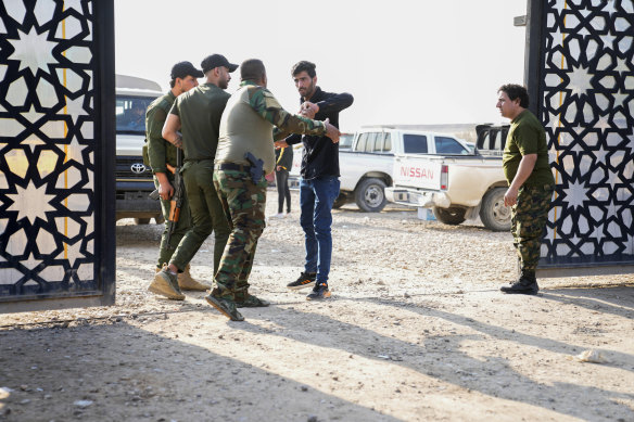 Members of an Iraqi Shiite militant group stand outside the headquarters of the Popular Mobilization Force after it was hit by an airstrike in Baghdad, Iraq.