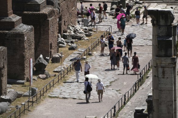 Tourists walk under a scorching sun at the Roman Forum in Rome.