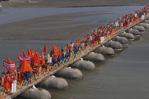 The holy men walk in a procession ahead of their dip.