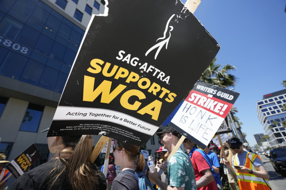 Picketers carry signs outside Netflix during a Writers Guild rally in Los Angeles.