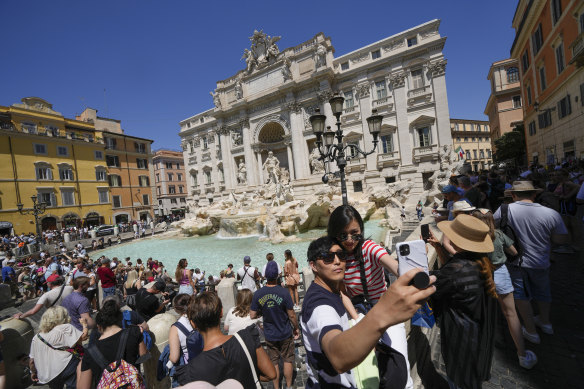 Tourists take a selfie at the Trevi Fountain in Rome.