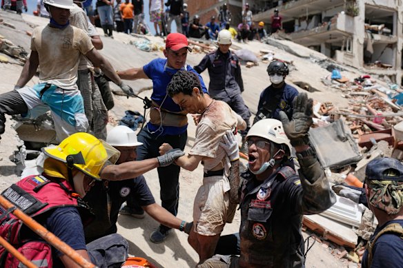Rescue workers pull a survivor, Daniel Cordero, from the rubble of his home two days after an earthquake struck Catia La Mar.