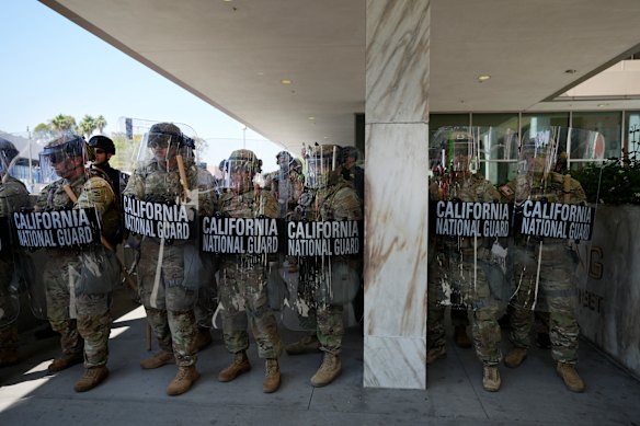 California National Guard troops form a line outside a federal building in downtown Los Angeles on Monday (Tuesday AEST).