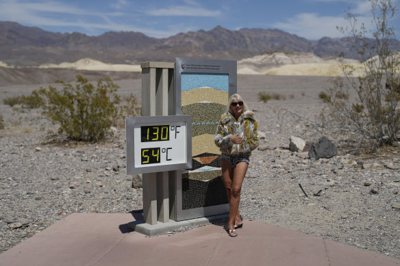 A woman poses by a thermometer in Death Valley National Park, Califonia. 