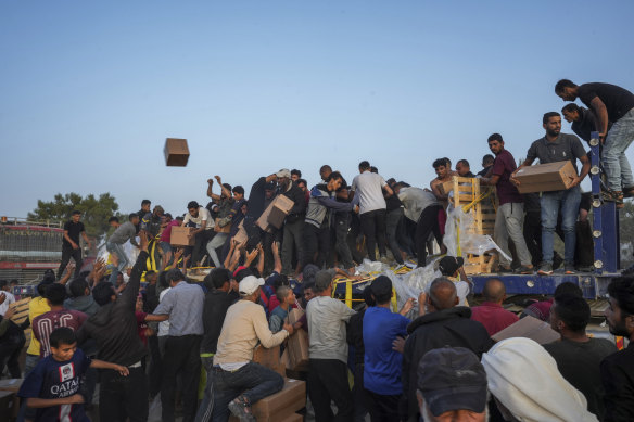 Palestinians storm a truck loaded with humanitarian aid brought in through a new US-built pier on Saturday.