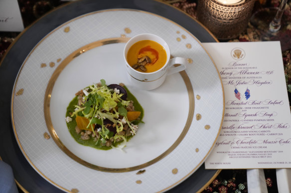 A menu is placed next to the first course of farro and roasted beet salad and butternut squash soup.