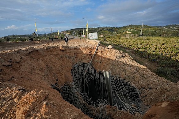 People inspect a crater following an Israeli airstrike that hit the Qasmiyeh Bridge near the coastal city of Tyre, Lebanon on Sunday.
