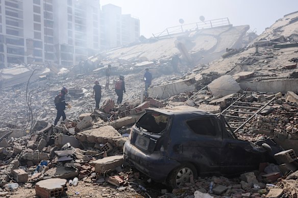 Rescue workers search through the rubble three days after earthquakes struck La Guaira.