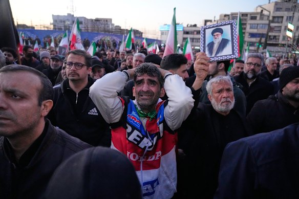 I sostenitori del governo piangono durante un raduno dopo che la TV di stato ha annunciato ufficialmente la morte del leader supremo iraniano Ayatollah Ali Khamenei, mostrata nel poster, a Teheran, Iran, domenica 1 marzo 2026.