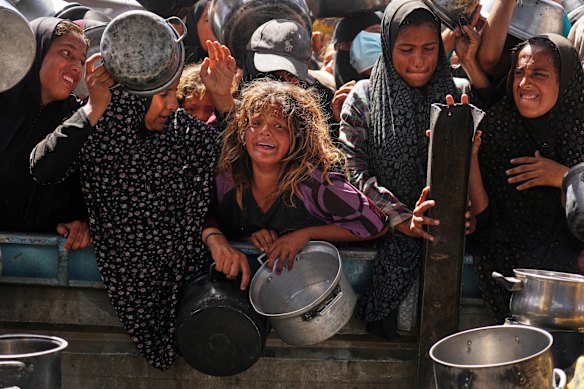 Palestinians struggle to get donated food at a community kitchen in Khan Younis late last week.