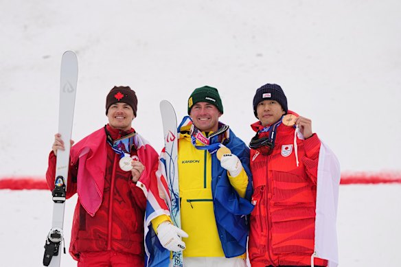 Cooper Woods on the podium with Mikael Kingsbury and Ikuma Horishima.