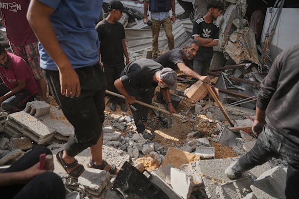 Palestinians search for survivors amid the debris of a building destroyed by an Israeli airstrike in Gaza City on Tuesday.