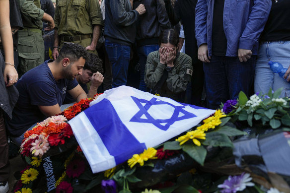 Mourners gather in grief around the grave of Israeli soldier Captain Harel Ittah during his funeral in Netanya, Israel.