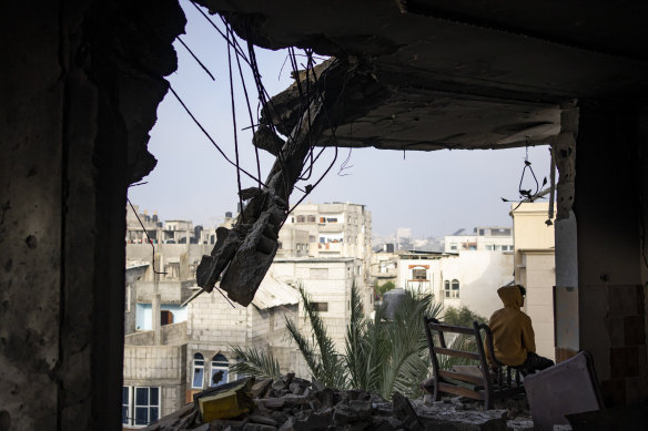 A Palestinian man sits in his house, which was destroyed in an Israeli strike, in Rafah, Gaza.