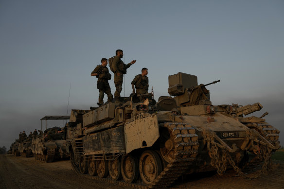 Israeli soldiers stand on top of armoured personnel carriers (APC) near the Israeli-Gaza border.