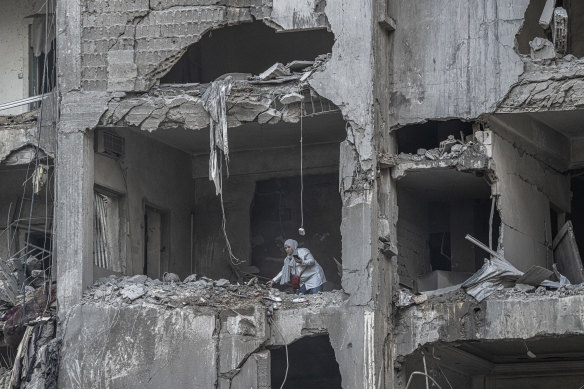 A resident looks through her belongings in an apartment destroyed by an Israeli airstrike.