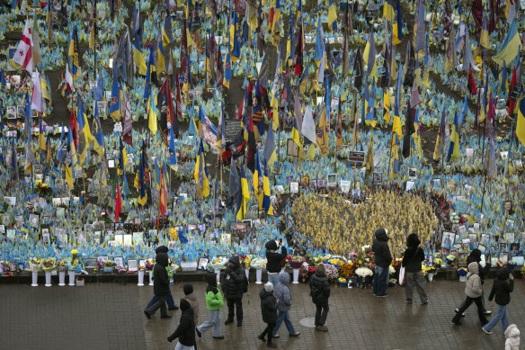 People walk past the memorial to fallen soldiers in Independence Square in Kyiv, Ukraine.
