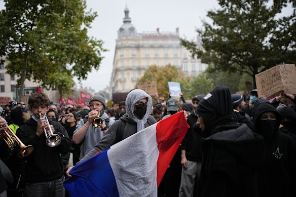 A protester in Lyon holds a French flag during a demonstration against rising living costs. 