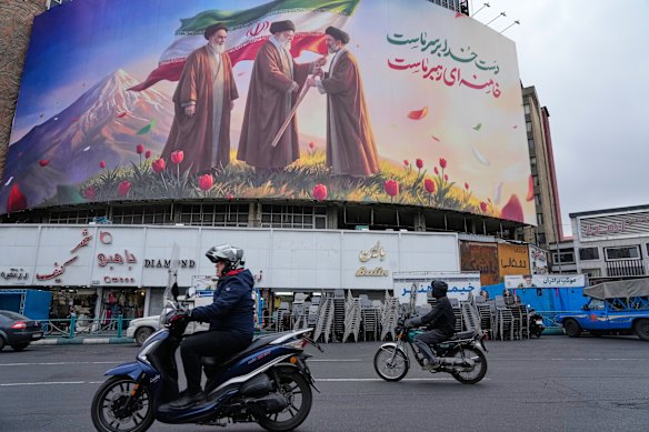 A billboard in downtown Tehran depicting Iran’s late supreme leader Ayatollah Ali Khamenei handing the country’s flag to his son and successor Ayatollah Mojtaba Khamenei.
