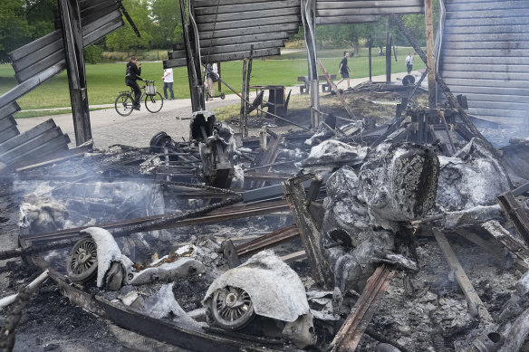People walk past a charred merry-go-round in a park of Nanterre, outside Paris.