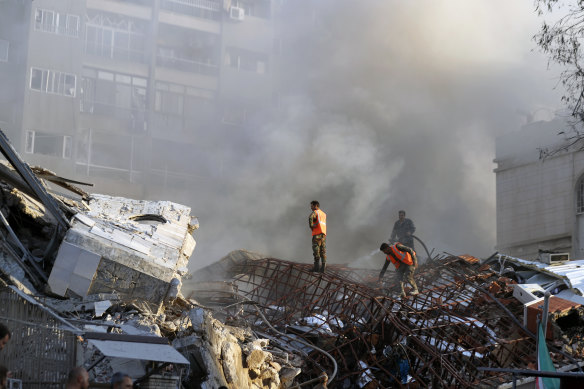 Emergency services work at the site of a destroyed building hit by an airstrike in Damascus, Syria.