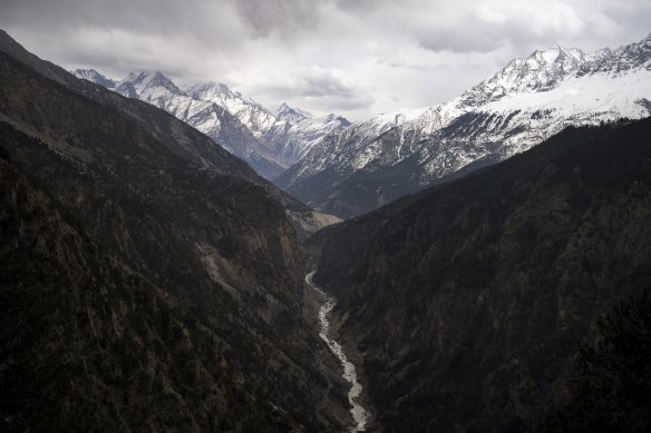 The Sutlej River flows in the valley below the tall snowy peaks in the Kinnaur district of the Himalayan state of Himachal Pradesh, India.
