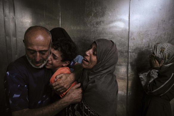 Raed Salem Aslyieh, hugs his relatives after the death of his son, Ahmed Raed Aslyieh, 18, who succumbed to injuries sustained in an Israeli strike, at the morgue of Shifa Hospital in Gaza City.