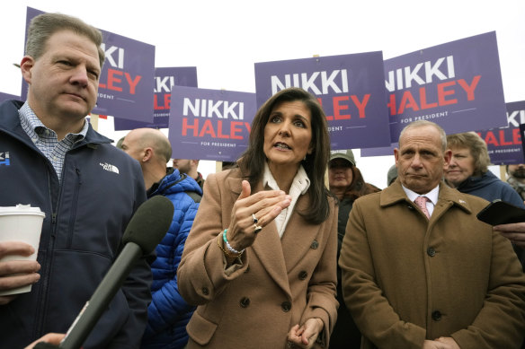 Nikki Haley speaks while standing with New Hampshire Governor Chris Sununu (left) and retired US Army Brigadier General Donald Bolduc near a polling place in Hampton, New Hampshire.
