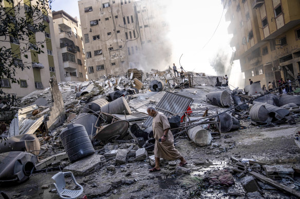 Palestinians inspect the rubble of a building after it was struck by an Israeli airstrike, in Gaza City