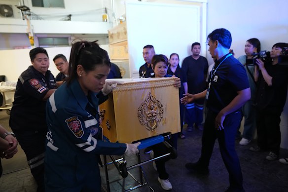 Una bara contenente il corpo di una vittima della sparatoria scolastica è portata in un ospedale di Bangkok sabato.