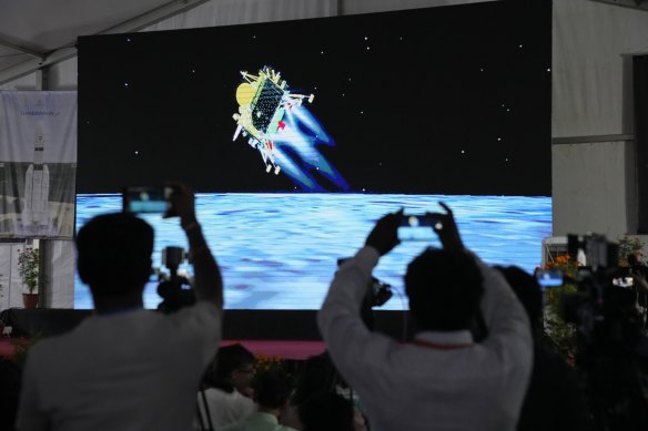 Journalists film the live telecast of spacecraft Chandrayaan-3 landing on the moon at ISRO’s Telemetry, Tracking and Command Network facility in Bengaluru, India.
