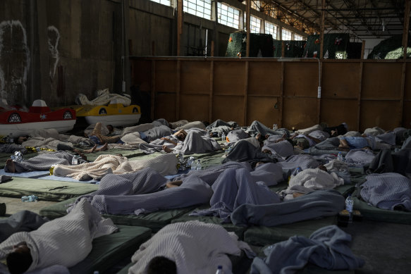 Survivors of a shipwreck sleep at a warehouse at the port in Kalamata, about 240 kilometres southwest of Athens.