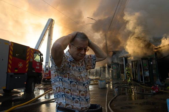 Bookseller Alexander Bahlai reacts as firefighters attempt to put out the fire at Kyiv’s book market.