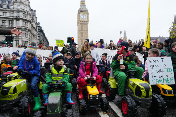 Children ride toy tractors in Parliament Square as demonstrators attend a farmers rally.