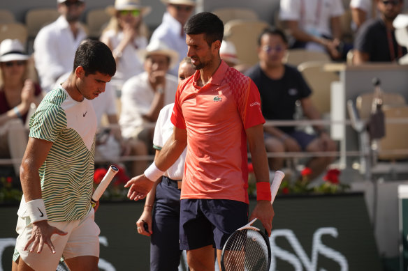 Novak Djokovic, right, accompanies Spain’s Carlos Alcaraz after he suffered leg cramps during their semifinal match of the French Open.