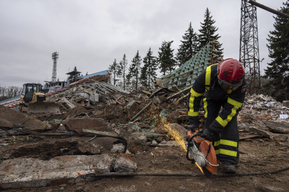 A firefighter works at a central stadium damaged by Russian forces’ shelling in Chernihiv, Ukraine,