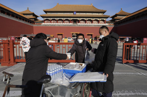Workers deliver meals for staff in front of the Forbidden City in Beijing on Wednesday.