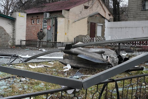 A man stands next to the consequences of Russian shelling in Kyiv.