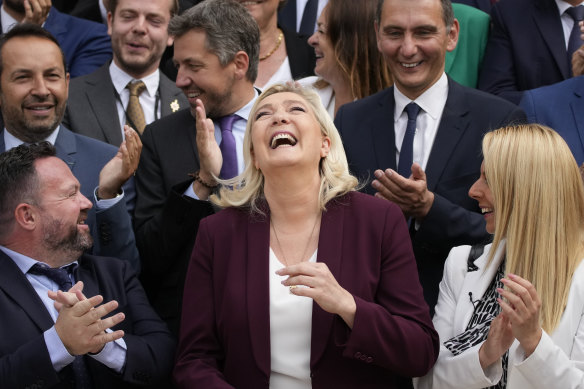 Tie Team: French far-right leader Marine Le Pen, centre, and National Rally party newly elected parliament members pose at the National Assembly last month.