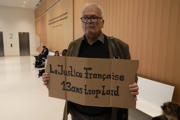 Bir adam, Airbus ve Air France şirketlerinin davasının başlamasından önce “13 yıl geç Fransız adaleti” yazan bir pankart taşıyor.